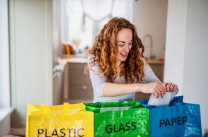 Woman Recycle Separating Glass Paper Plastic