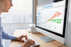 Woman on Computer with Climate Change Chart