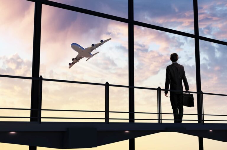 Businessman at Airport watching Airplane Taking Off